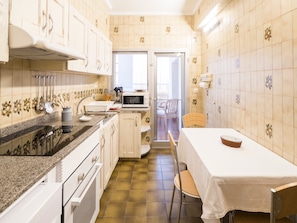 A compact kitchen with a microwave, sink, and wooden cabinets.