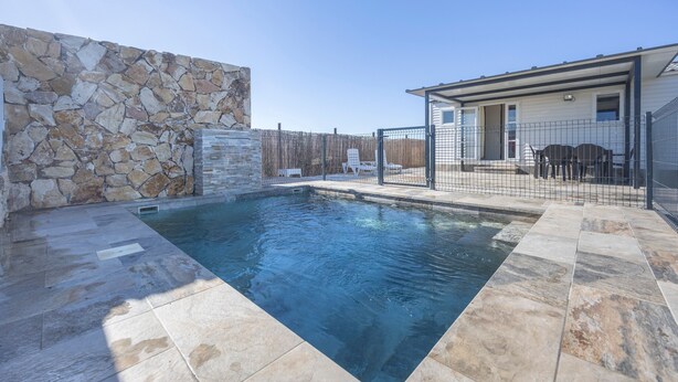 A swimming pool with stone walls and a fenced patio area. - Bungalow 'Tranquilo Cerca De Roche' with Private Pool, Wi-Fi and Air Conditioning (Conil de la Frontera)
