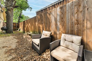 A patio area with wicker chairs and a wooden fence. - 2 Mi to Denton Square! Spacious Home w/ Backyard (Denton)