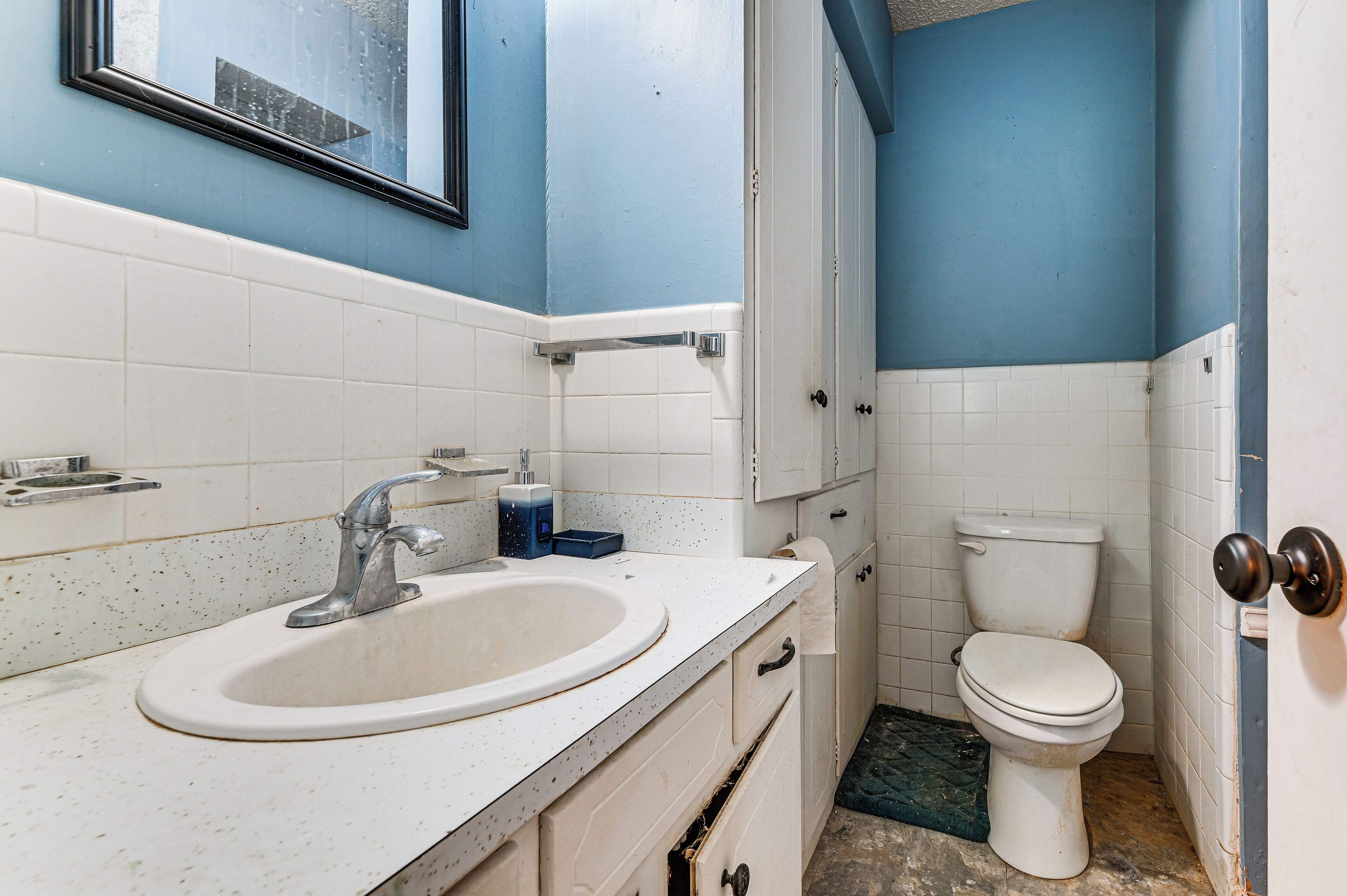 A bathroom with a sink, toilet, and blue walls.