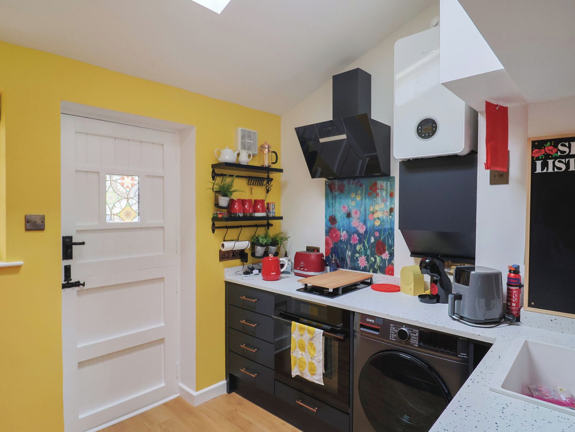A compact kitchen with a built-in oven, a coffee maker, and a microwave.