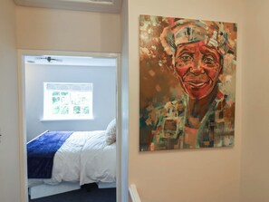 A bedroom with a bed, a window, and a painting on the wall. - No. 6 (Bridport)