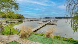 A calm lake with wooden docks and a grassy area. - Dock, Deck & Sunsets! Little Bungalow on Lake Mary (Twin Lakes)