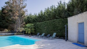 A swimming pool with lounge chairs, a blue door, and a hedge. - Les2toits Loft with Pool in the Heart of Sologne (Pruniers-en-Sologne)