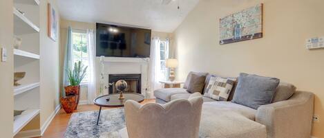 A living room with a fireplace, a ceiling fan, and a sofa.