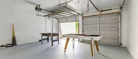 A garage with a pool table, a ceiling fan, and a garage door.
