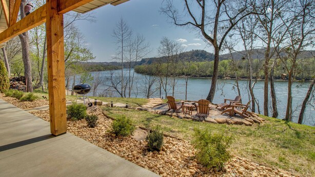 A covered patio with outdoor furniture, a grill, and a view of a lake surrounded by trees. - 'coppertop Cabin' Waterfront White River Retreat (Norfork)