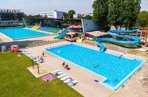 A swimming pool with adjacent seating and a water slide.
