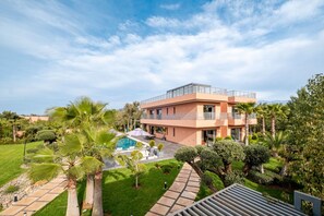 A modern hotel with a pool, surrounded by lush greenery and palm trees. - Pool • Retreat at Villa Taroub • 4 Suits • Gym (Marrakesh)