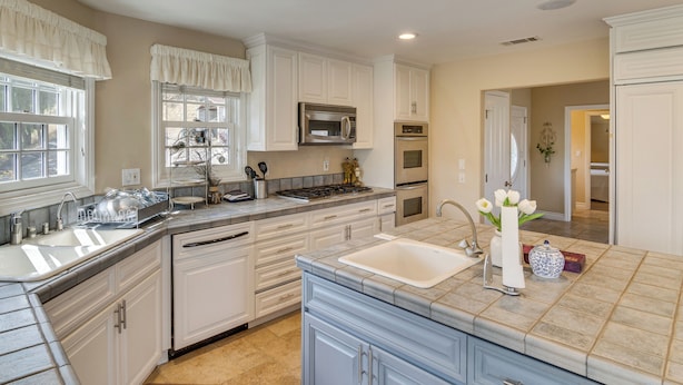A kitchen with white cabinetry, a stainless steel microwave, an oven, and a sink. - Amazing Mtn & City Views! Simi Valley Hideaway (Simi Valley)