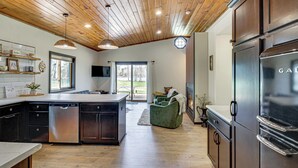 A modern kitchen with wooden ceiling, stainless steel appliances, and a large island. - Long Lake Cabin w/ Dock: Fish & Hike! (Akeley)