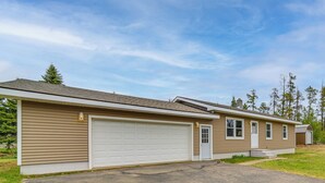 A single-story residential building with a garage, a front door, and a small porch. - Explore the Upper Peninsula! Marquette Home (Marquette)