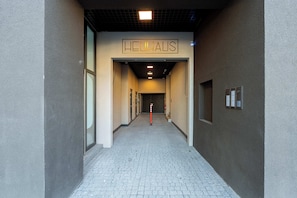 A hallway with a sign reading 'HEUHAUS' leading to a door.