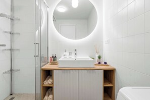 Chuveiro, secador de cabelo, toalhas de banho, shampoo