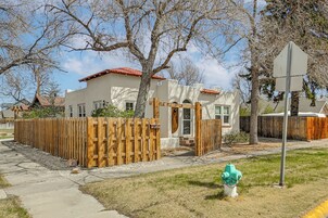 Una casa residencial con una valla de madera, un hidrante verde y una señal de parada.