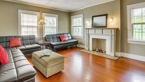 A living room with a fireplace, leather sofas, and a large window.