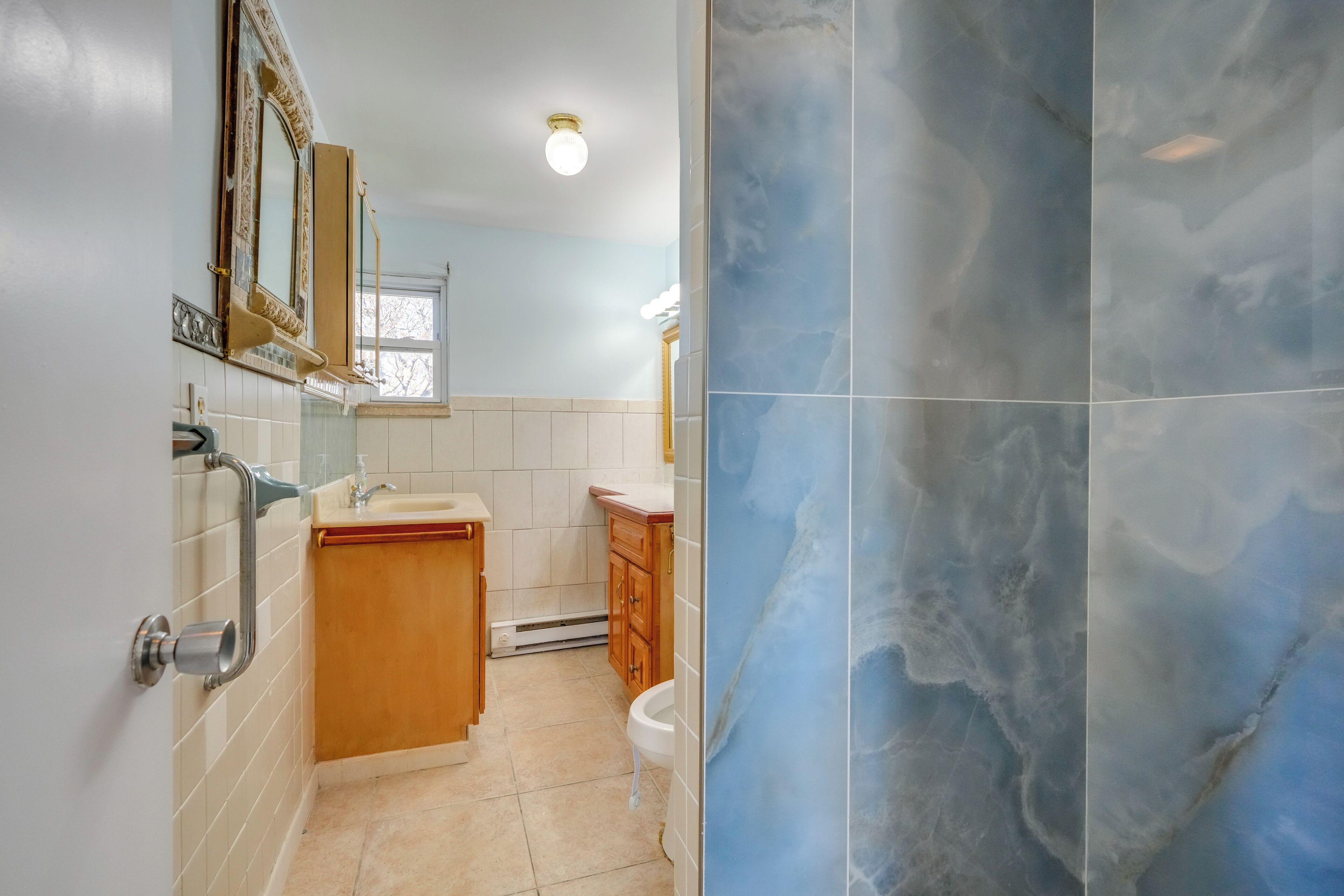 Un baño con lavabo, espejo, tocador y retrete.