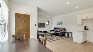 A modern living room with a dining table, leather sofa, and a kitchen area with white cabinets. - Easy Dtwn Access! Prime PHX Stay For Couples (Phoenix)