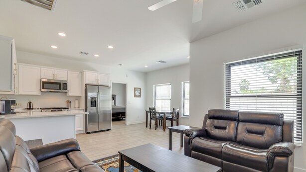 A modern living room with a sofa, coffee table, and a dining area with chairs and a table. - Easy Dtwn Access! Prime PHX Stay For Couples (Phoenix)