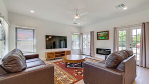 A modern living room with a sofa set, a coffee table, and a flat-screen TV mounted on the wall. - PHX Group Retreat By Dtwn! New Build w/ Patio (Phoenix)