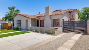 A modern two-story house with a tiled roof, a brick chimney, and a gated driveway. - PHX Group Retreat By Dtwn! New Build w/ Patio (Phoenix)