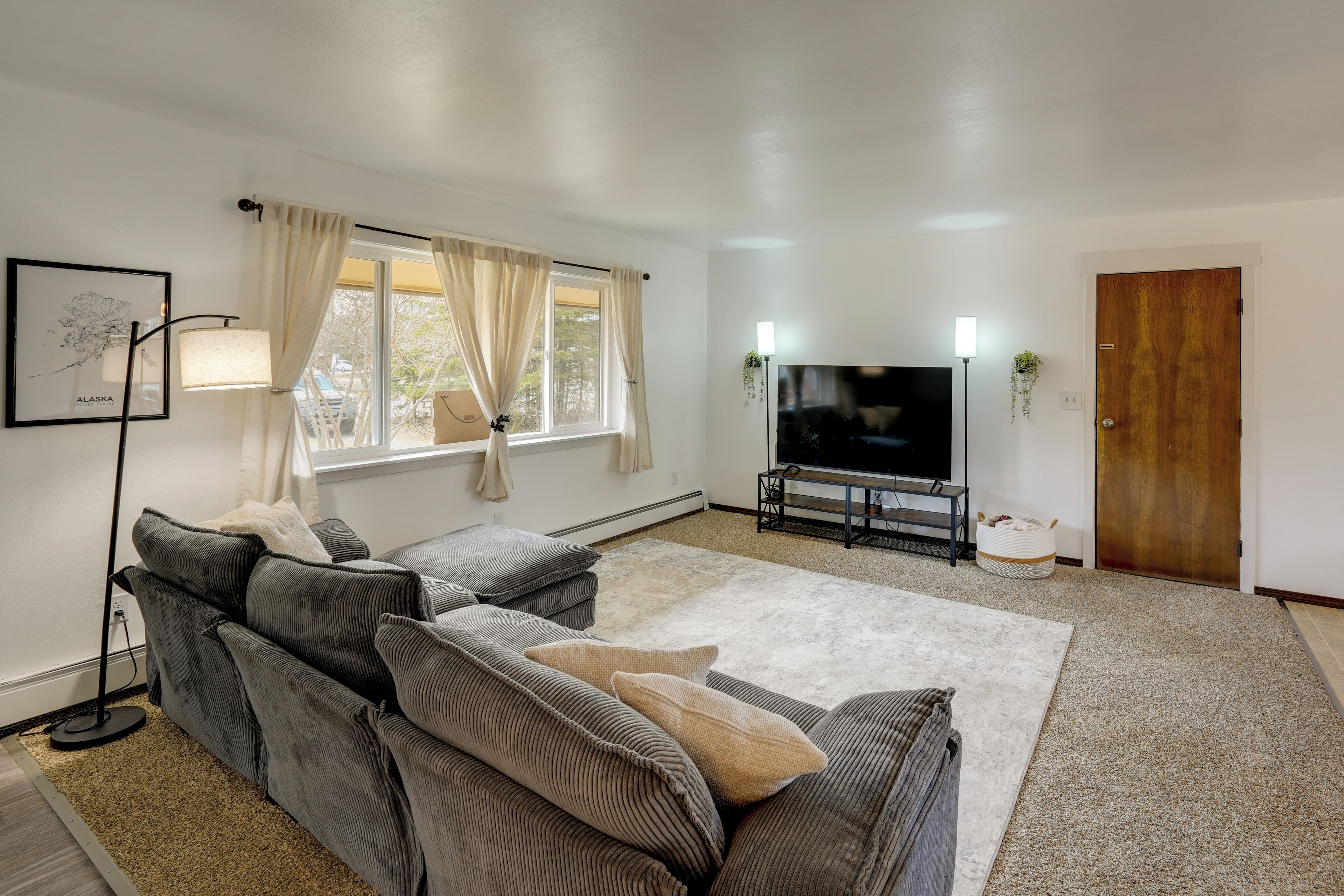 A living room with a sofa, TV, and a wooden door.