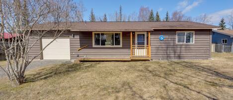 A single-story house with a front porch, a garage, and a small deck.