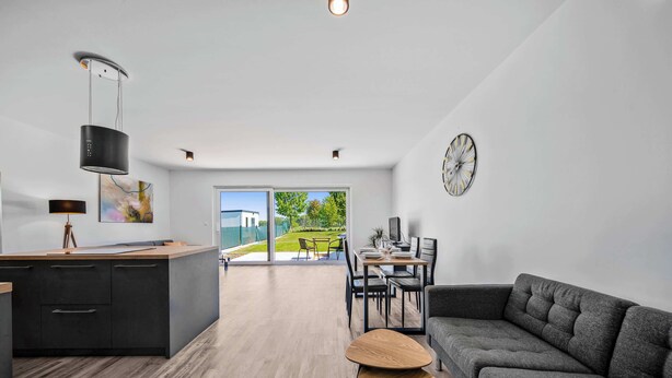 Una cocina moderna con comedor, sofá y vistas al exterior.
