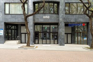 A modern building with a sign reading 'UNO POSTIVA RESIDENCE' and another sign for 'SLOVENSKA sportfella.' - The Heart of Shopping & City Life (Bratislava)
