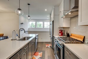 A modern kitchen with stainless steel appliances, a wooden countertop, and a view of the outdoors. - 1 Mi Decatur Square New Condo Walkable to Marta (Decatur)