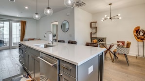 A modern kitchen with a central island, stainless steel appliances, and pendant lighting. - 1 Mi Decatur Square New Condo Walkable to Marta (Decatur)