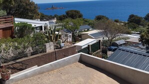 Un quartier résidentiel offrant une vue sur la mer, des maisons et un promontoire rocheux.