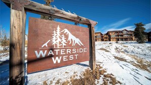 Schild für Waterside West mit einem Baum und einem Berg im Logo.