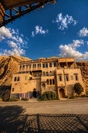 A large, multi-story building with a prominent entrance and a balcony.