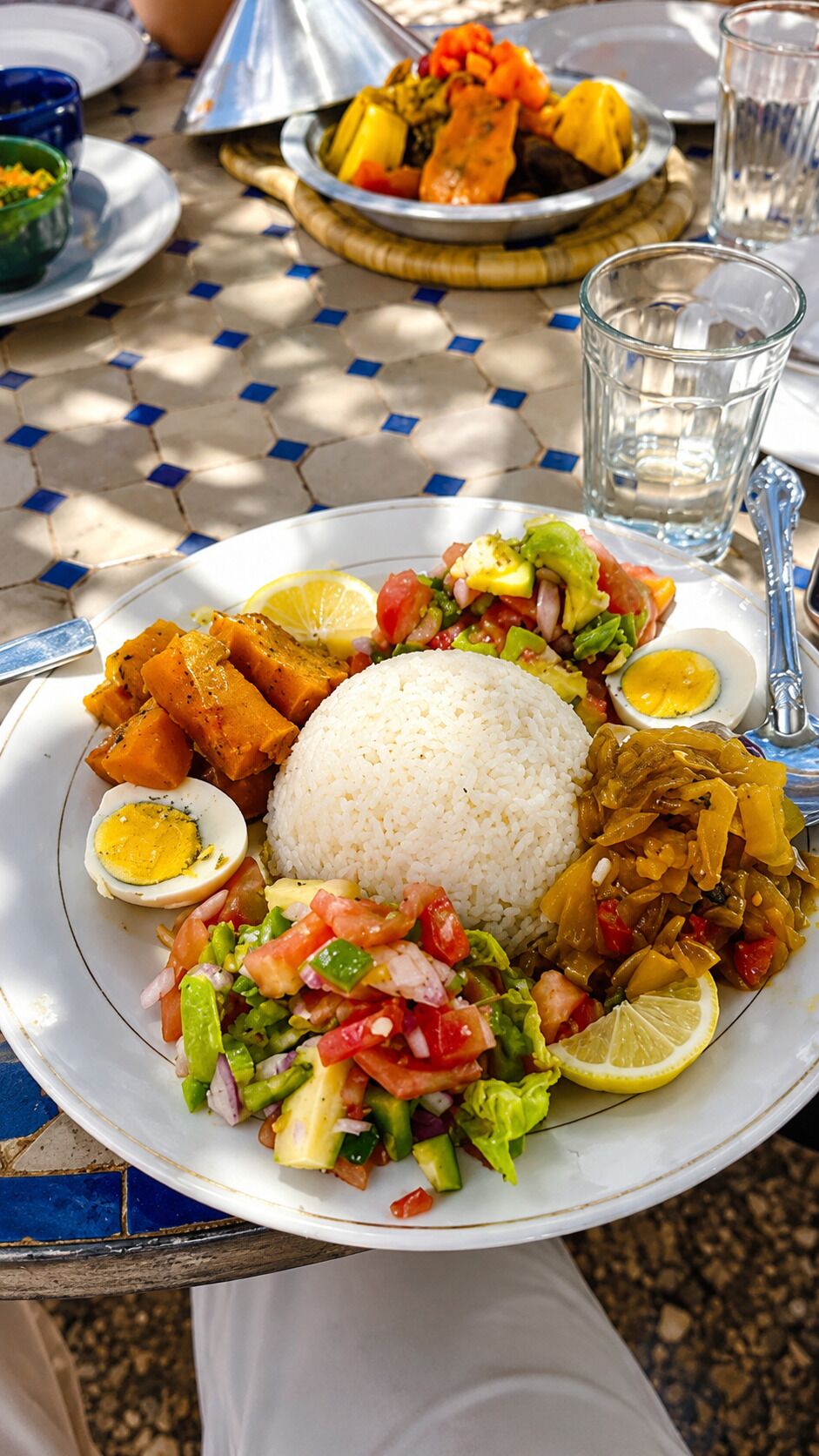 Un plato de comida con arroz, verduras y un huevo cocido.