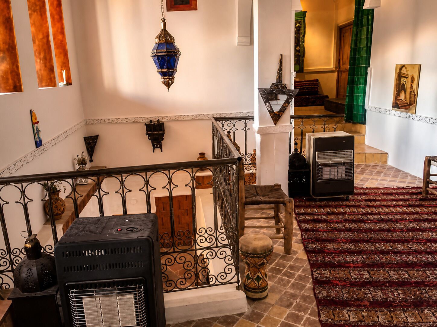 A staircase with a metal railing, a patterned carpet, and a decorative lantern.