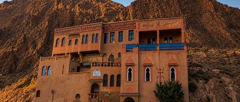 A multi-story building with a traditional architectural style, featuring arched windows and a balcony.