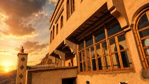 Un edificio con ventanas de arco y un balcón con cerámica tradicional.