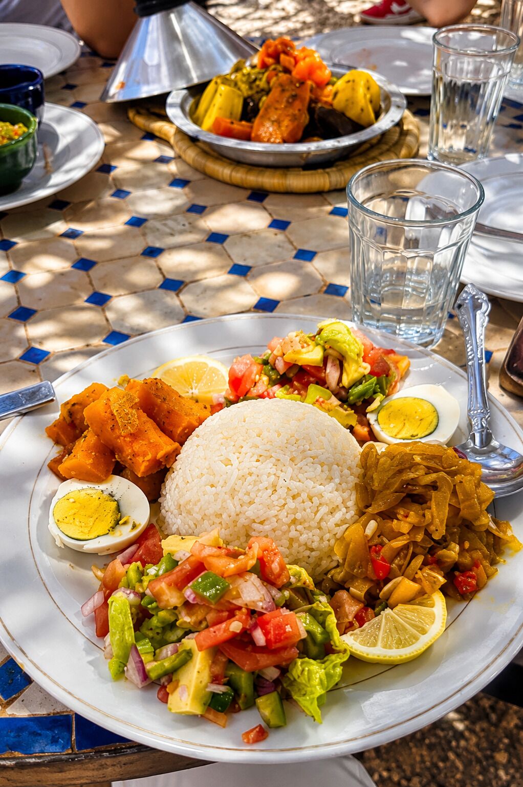 Un plato de comida con arroz, ensalada y un huevo duro.