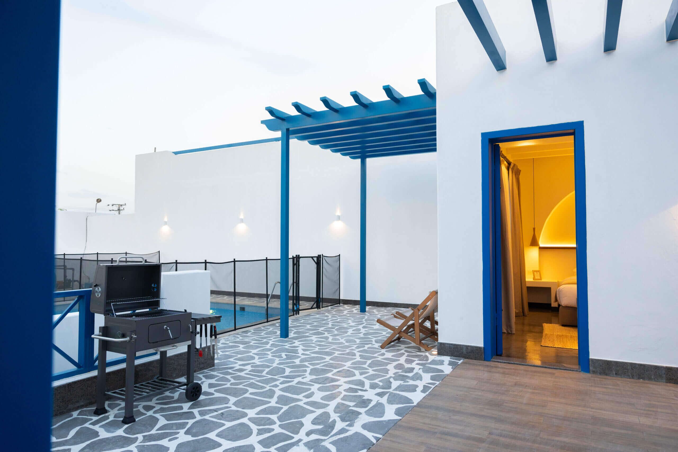 Eine Dachterrasse mit Grill, Pool und Eingang zu einem Schlafzimmer.