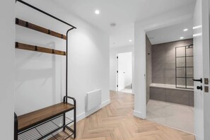 Un interior moderno con un banco, un perchero y una zona de ducha.