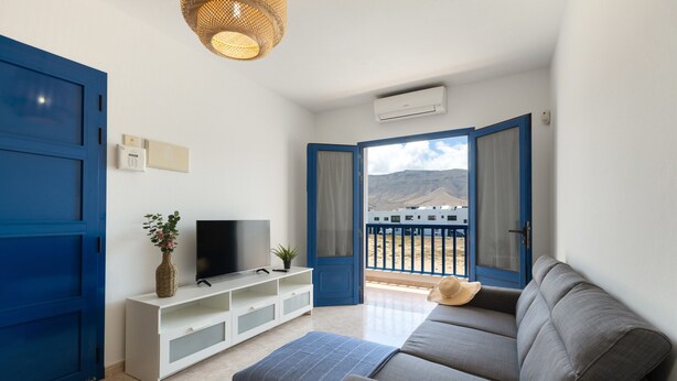 A living room with a sofa, TV, and a plant. - Famara Cactus by Escape Home (Famara)
