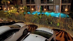 A hotel with a swimming pool, parked cars, and a fence. - Gamboa Oasis Patacho 180m from the beach on the Ecological Route of Miracles (Porto de Pedras)