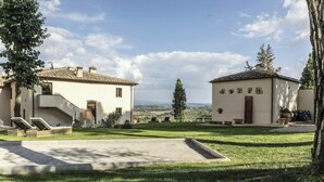 Une villa dotée d’une allée pavée, d’une pelouse verdoyante et offrant une vue sur la campagne.