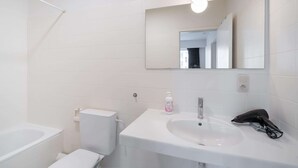 A bathroom with a white sink, mirror, and toilet. - Apartment in the Heart of Antwerp (Antwerp)