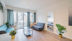 Uma sala de estar moderna com sofá, mesa de centro e planta em vaso.