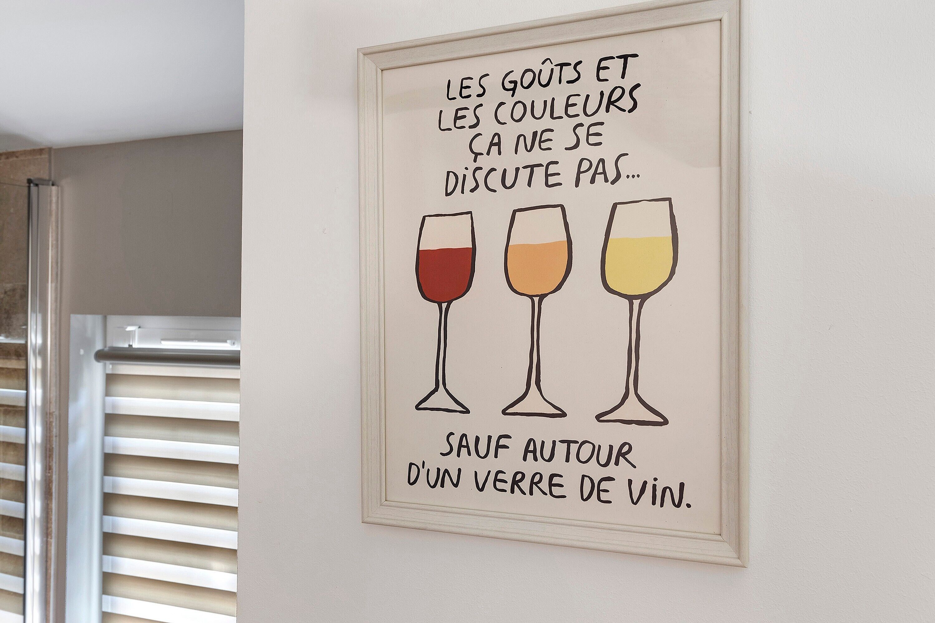 A framed sign with wine glasses and text in French.