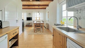Een keuken met houten vloeren, een eettafel en een inbouwgootsteen.