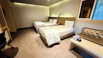 A hotel room with two beds, a sofa, a desk, and a mirror.