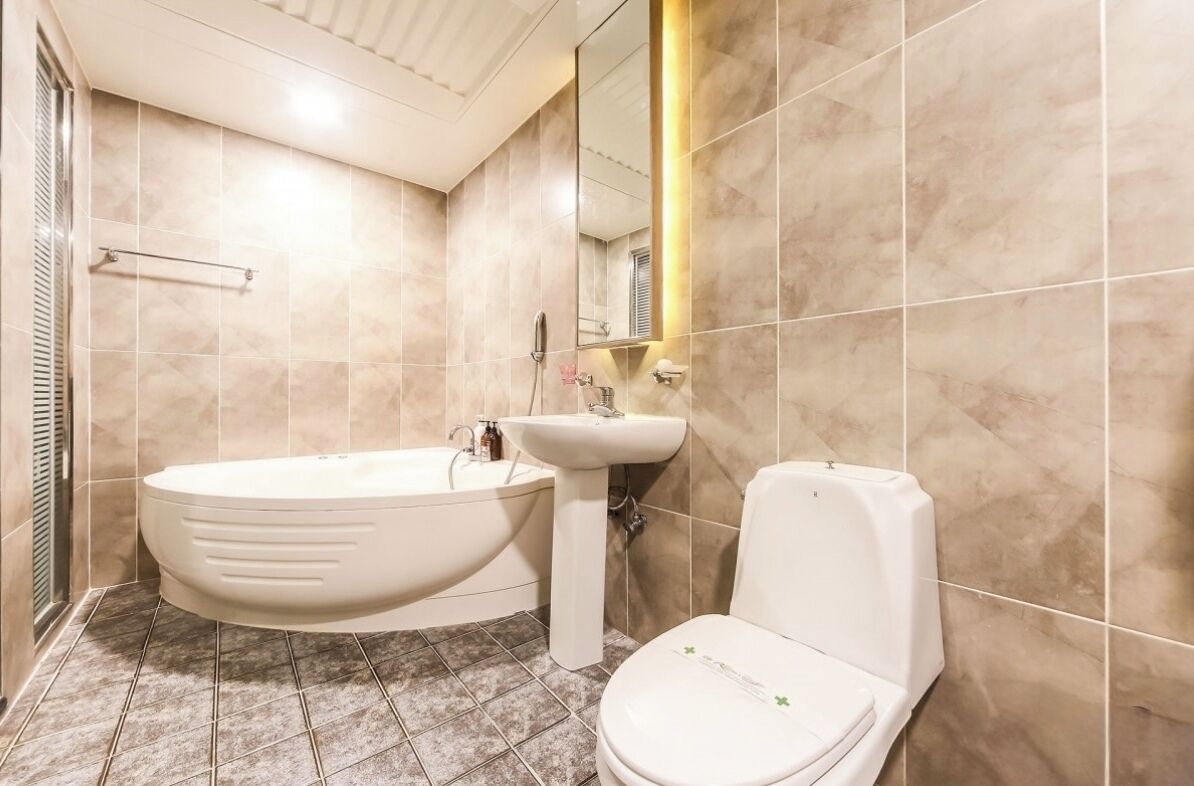 Un baño con bañera, lavamanos e inodoro.